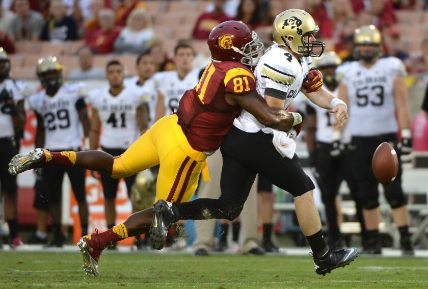 USC's Kevin Greene forces Colorado quarterback Jordan Webb to fumble the ball during a game at the Los Angeles Memorial Coliseum.