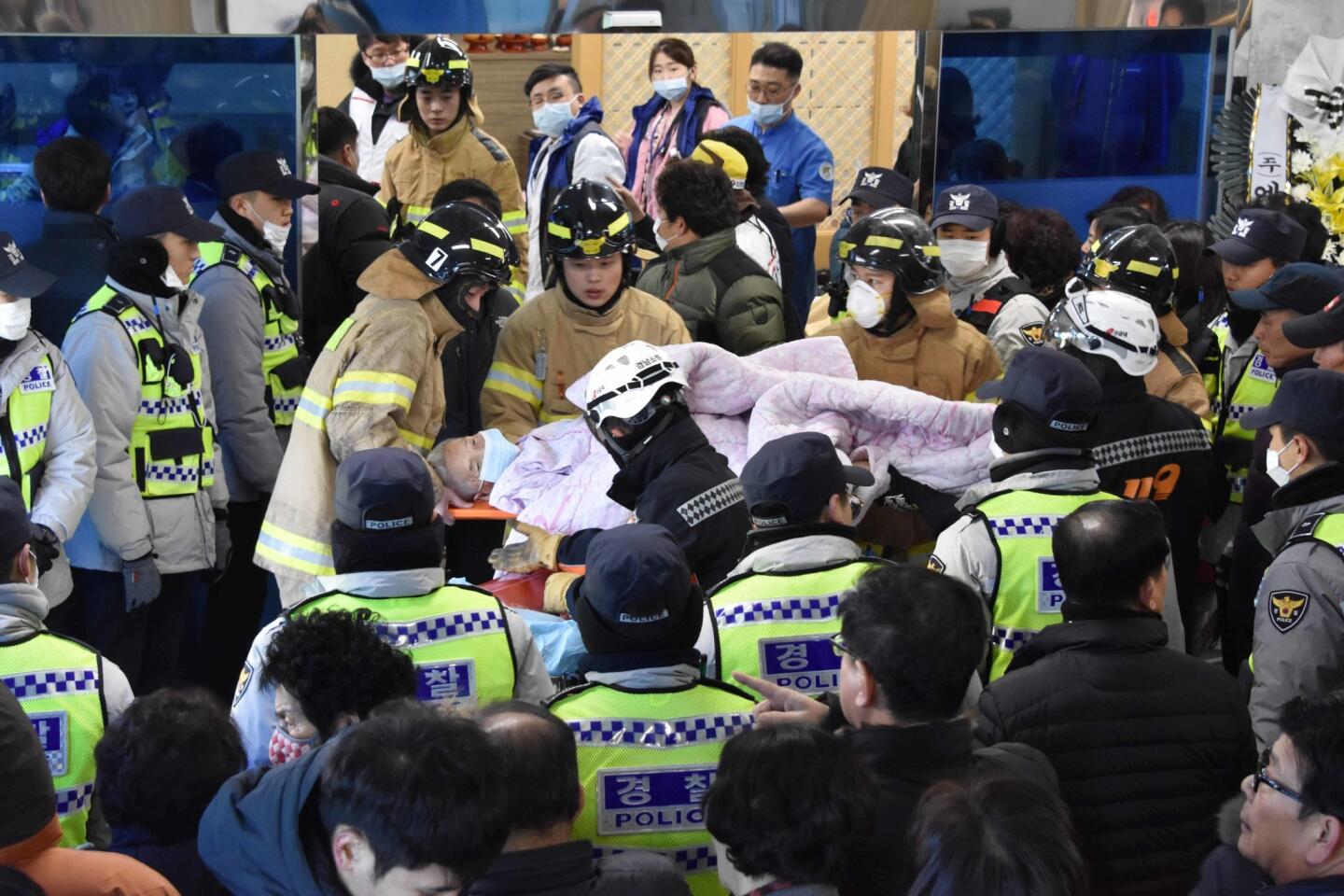 Firefighters carry a victim after the hospital fire in Miryang, South Korea.