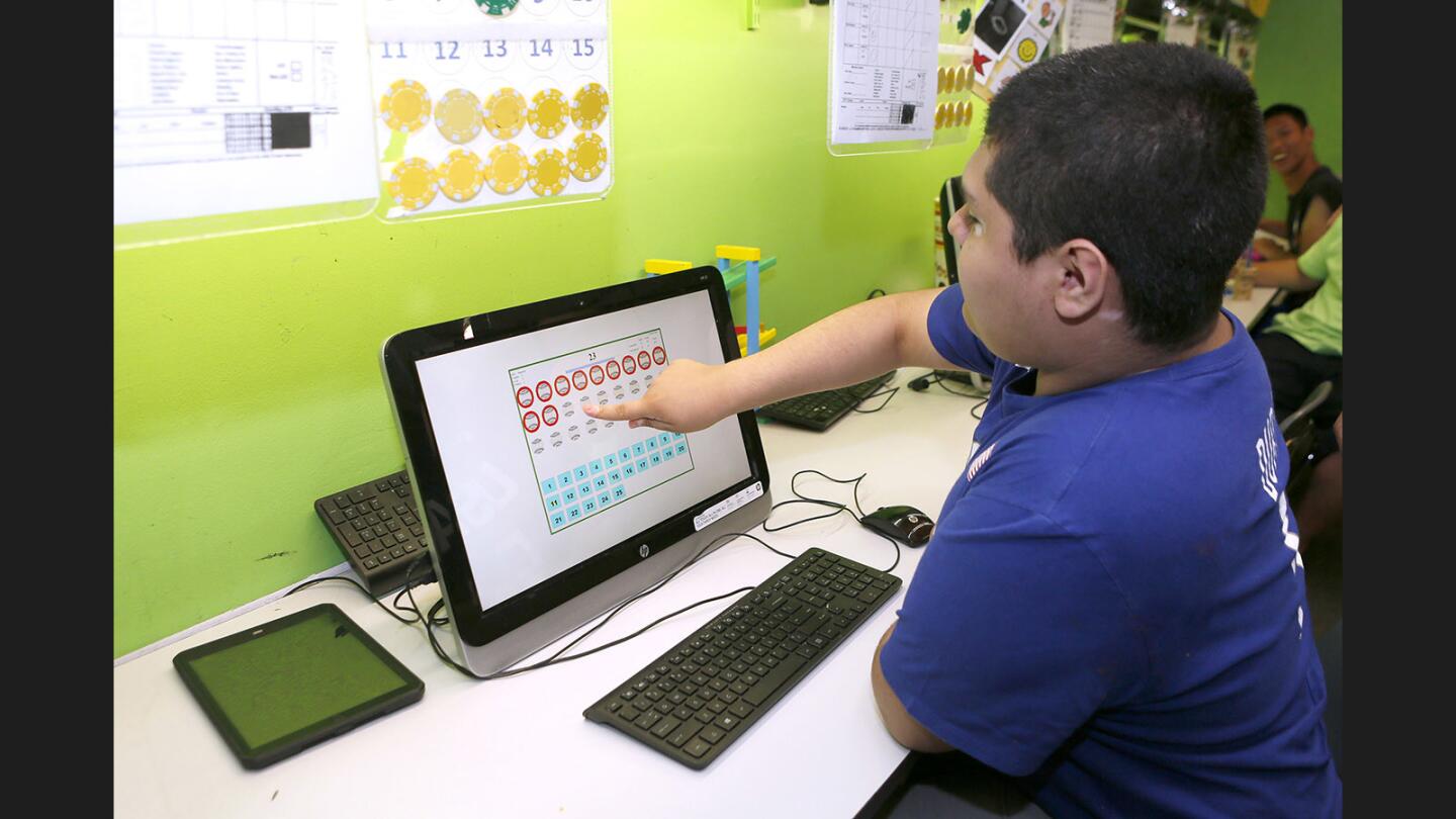 A student named Gerardo works on counting on a computer in the precision teaching program at Tobinworld's Brill School of Autism, in Glendale on Tuesday, June 27, 2017. Students in the class learn how to communicate with pictures, how to work for periods of time, behavior, and ability to communicate their needs.