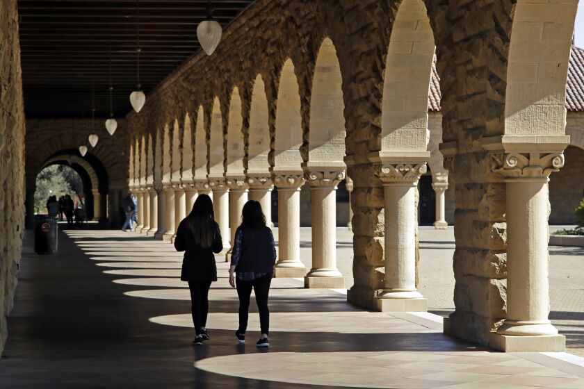 FILE — Students walk on the Stanford University campus in Stanford, Calif, March 14, 2019. When students at Stanford University return to campus in January 2022, they'll be barred from holding parties or other big gatherings for two weeks. (AP Photo/Ben Margot, File)