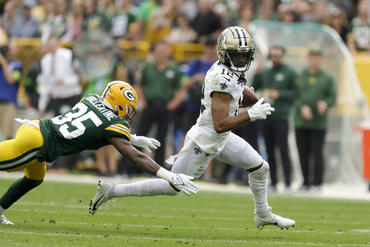 New Orleans Saints wide receiver Chris Olave runs past Green Bay Packers cornerback Corey Ballentine.