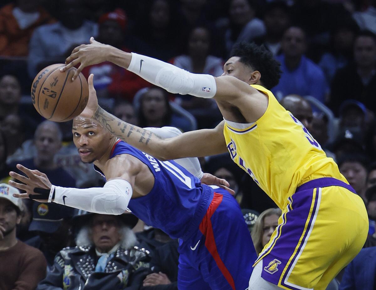 Lakers forward Christian Wood, right, and Clippers point guard Russell Westbrook battle for a loose ball.