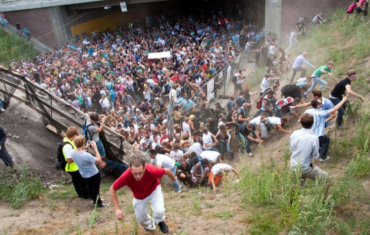 People flee during a mass panic at the Love Parade techno music festival in Duisburg, Germany, in 2010. Prosecutors have filed criminal charges against 10 people in the incident, which resulted in 21 deaths.