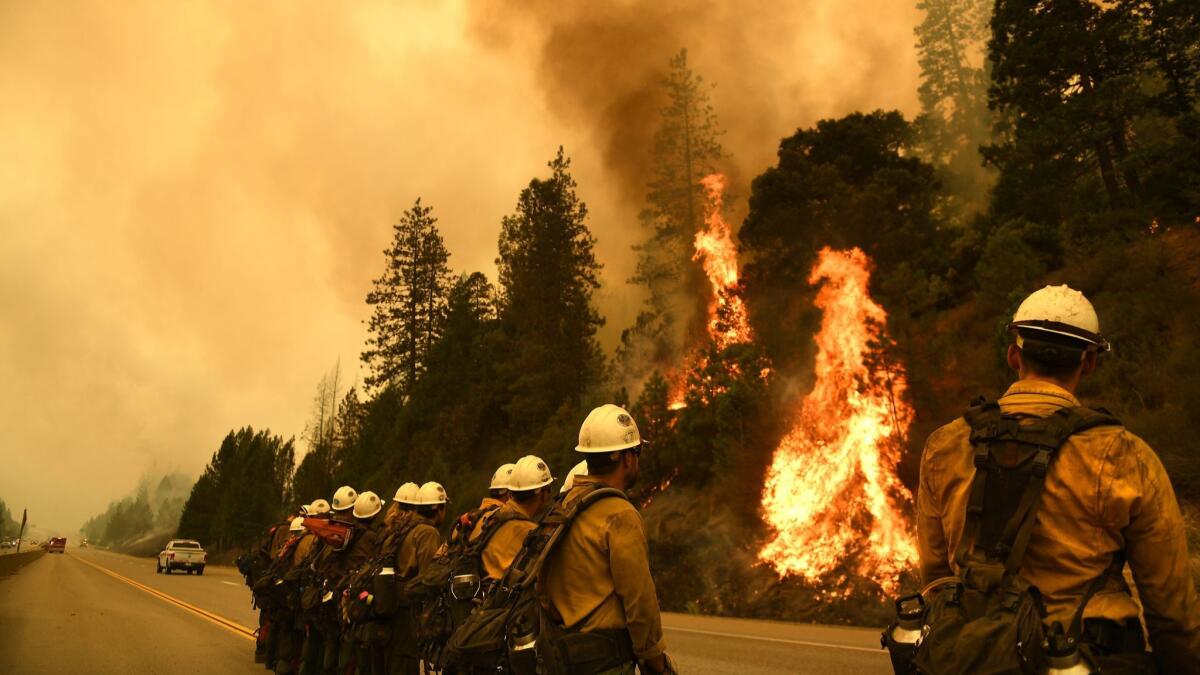 Firefighters monitor the Delta Fire along the 5 Freeway north of Redding on Friday.