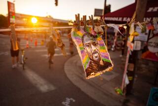 MINNEAPOLIS, MN - JULY 26: As the sun sets over Minneapolis the day's final beams of light illuminate a cloth painting of George Floyd gracefully waving in the summers breeze near where he died on Sunday, July 26, 2020 in Minneapolis, MN. (Jason Armond / Los Angeles Times)