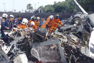 En esta imagen, distribuida por el Departamento de Bomberos y Rescate de Malasia, varios operarios inspeccionan el lugar donde se estrellaron dos helicópteros militares, en Lumur, en el estado de Perak, el 23 de abril de 2024. (Terence Tan/Ministerio de Comunicación e Información vía AP)