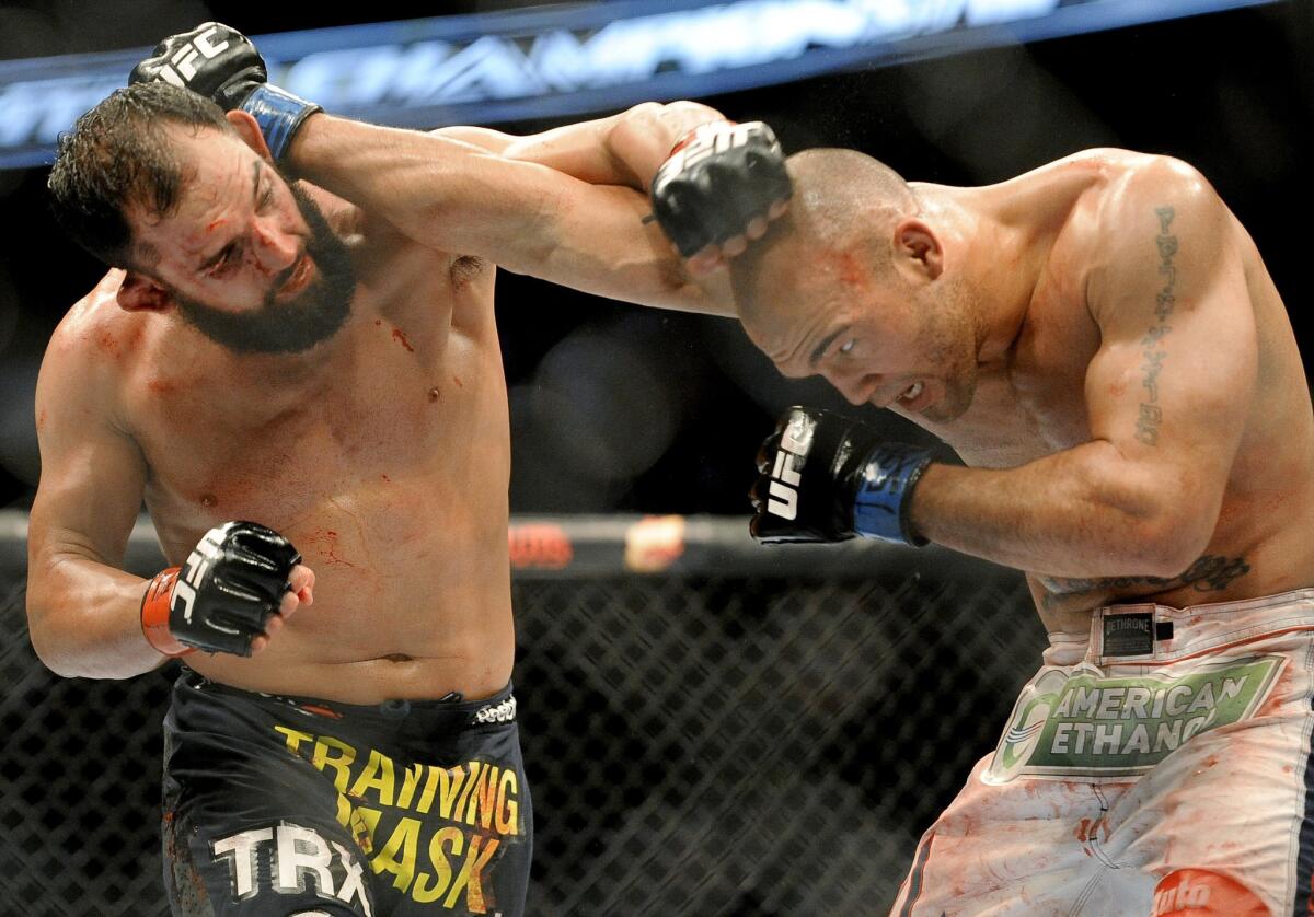 Johny Hendricks and Robbie Lawler, right, exchange blows during a UFC 171 welterweight title bout in March. Hendricks won by decision.