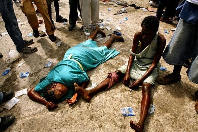 Two women collapse from exhaustion in Port-au-Prince, Haiti. 