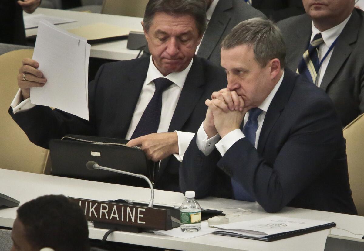 Yuriy Sergeyev, Ukrainian Ambassador to the U.N., left, and Ukraine's acting Foreign Minister Andrii Deshchytsia, right, listen to speakers as the General Assembly debates a resolution rebuking Russia for its actions in Crimea.