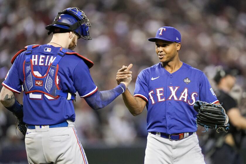 Texas Rangers reliever Jose Leclerc and catcher Jonah Heim celebrate a World Series win on Oct. 30, 2023, in Phoenix.