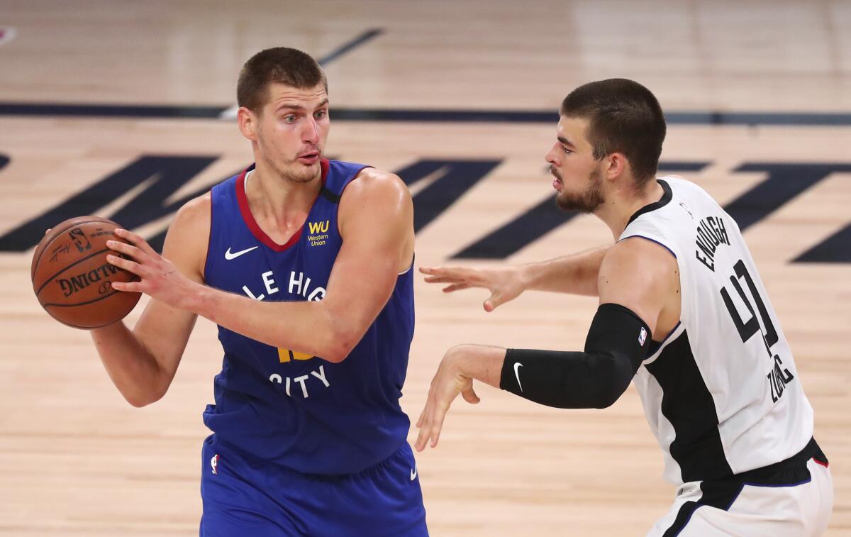 Nuggets center Nikola Jokic is defended by Clippers center Ivica Zubac on Aug. 12, 2020.