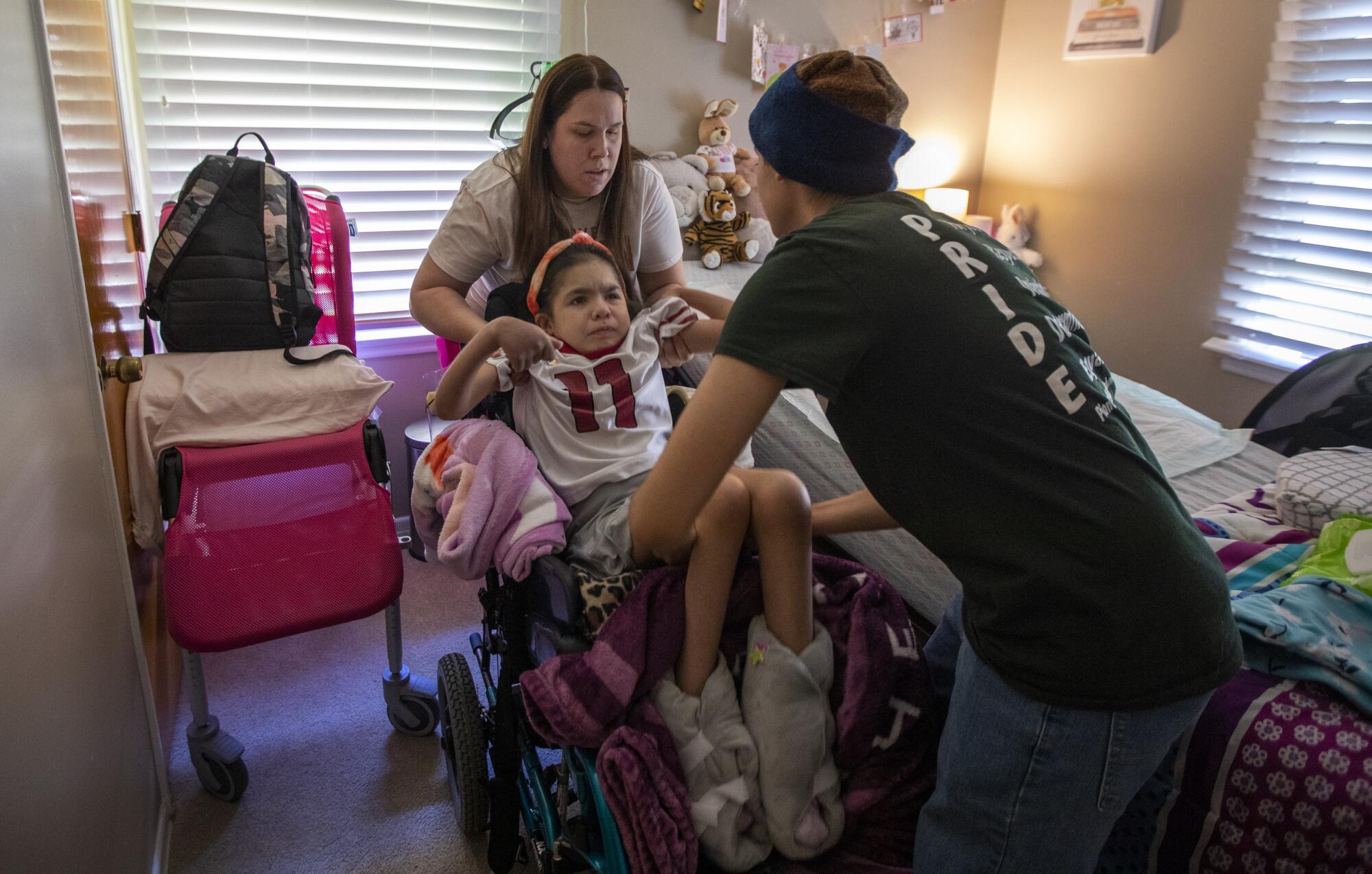 Penny Lopez, left, lifts her daughter Hannah with help from her son Lucas.
