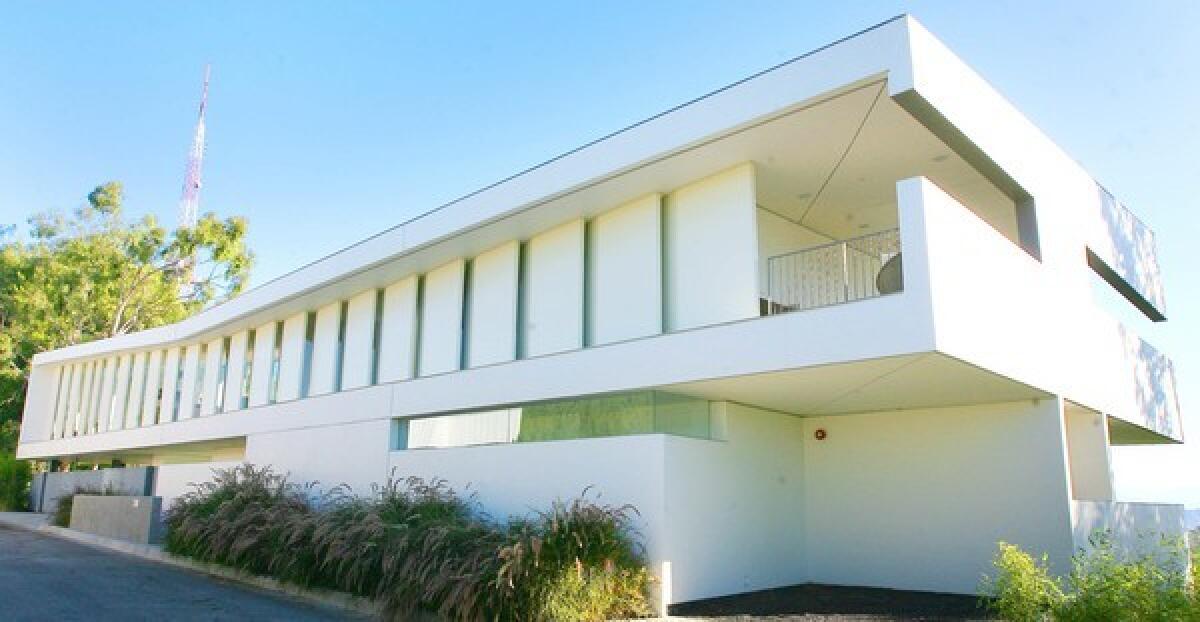 By Chris Iovenko With a long span of angled panels lining its futuristic facade, this L.A. house near Mulholland Drive looks monumental, almost imposing. But pass through the front gate and enter the main living area, and one feels a remarkable sense of air and light. At a time when so many people are looking for an escape from reality, the home of Don and Debbie Caverhill certainly provides one. After a 1.5-year design process and another 1.5 years of construction, the home by Culver City-based Studio Pali Fekete Architects now stands as a contemporary indoor-outdoor replacement for the old house that once stood on the difficult site.