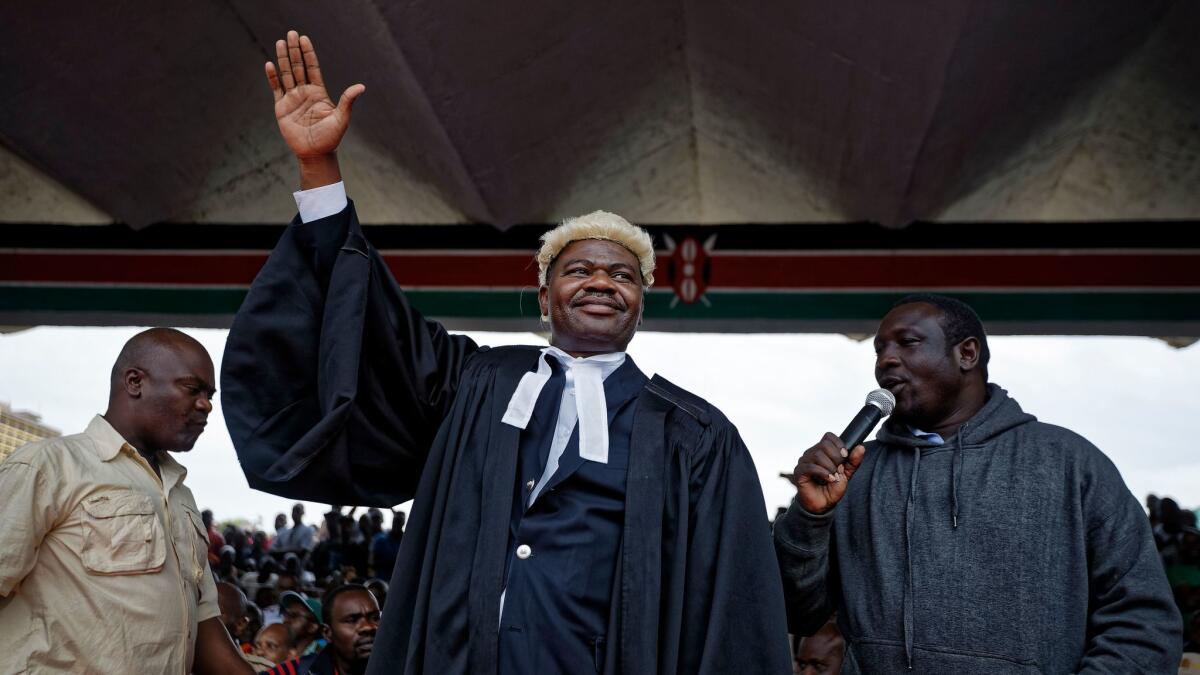 Kenyan opposition legislator and lawyer Tom Kajwang gestures to the crowd as he attends a mock swearing-in ceremony for opposition leader Raila Odinga in Nairobi on Tuesday.