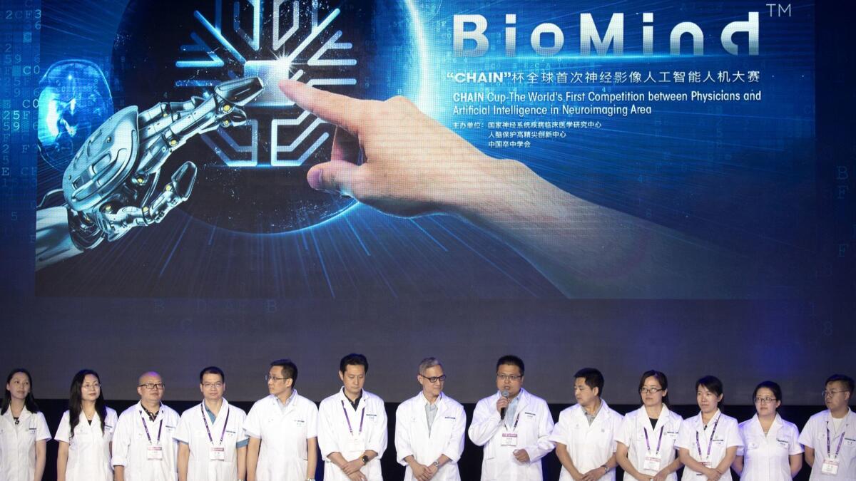 A team of doctors line up before the start of the competition pitting physicians against a robotic "doctor" at the China National Convention Center in Beijing on June 30, 2018.