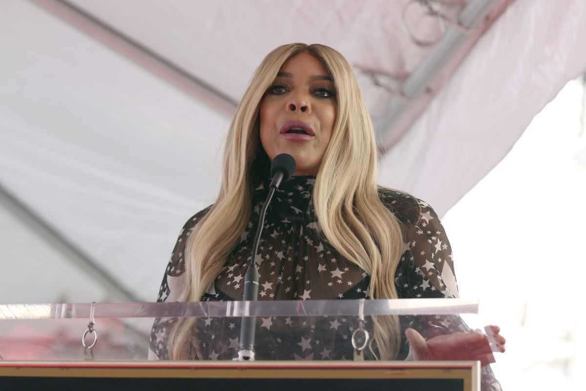 Wendy Williams speaks into a microphone on a lectern