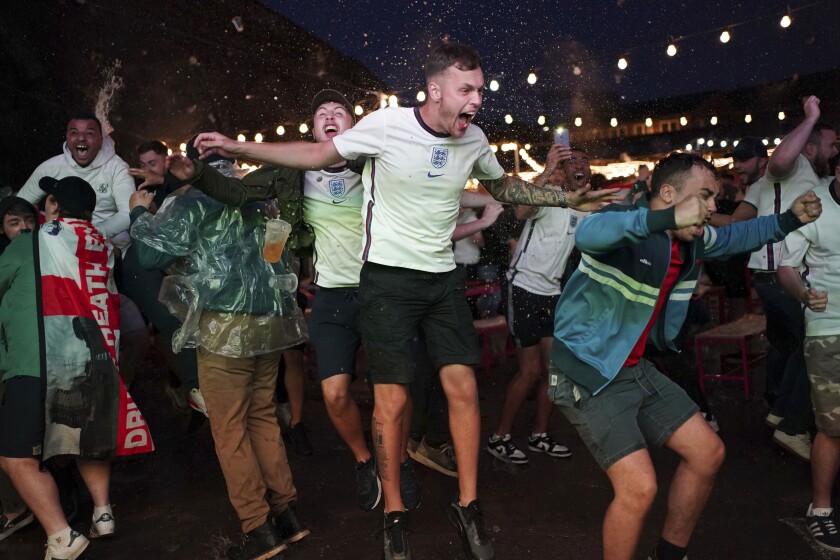 Fans of England celebrate the second goal scored by Harry Kane at Luna Springs in Birmingham, England, while they watch the Euro 2020 soccer championship semifinal match between England and Denmark, remotely on Wednesday, July 7, 2021. (Jacob King/PA via AP)
