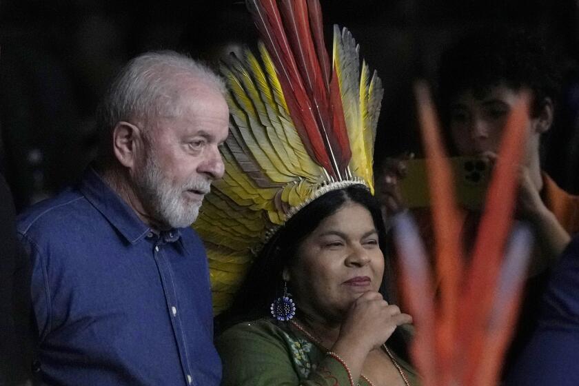 El presidente brasileño Luiz Inácio Lula da Silva y la ministra de los Pueblos Indígenas, Sônia Guajajara, llegan a la ceremonia de clausura de la 1ra Reunión Ordinaria del Consejo Nacional para Políticas Indígenas, el jueves 18 de abril de 2024, en Brasilia, Brasil. (AP Foto/Eraldo Peres)