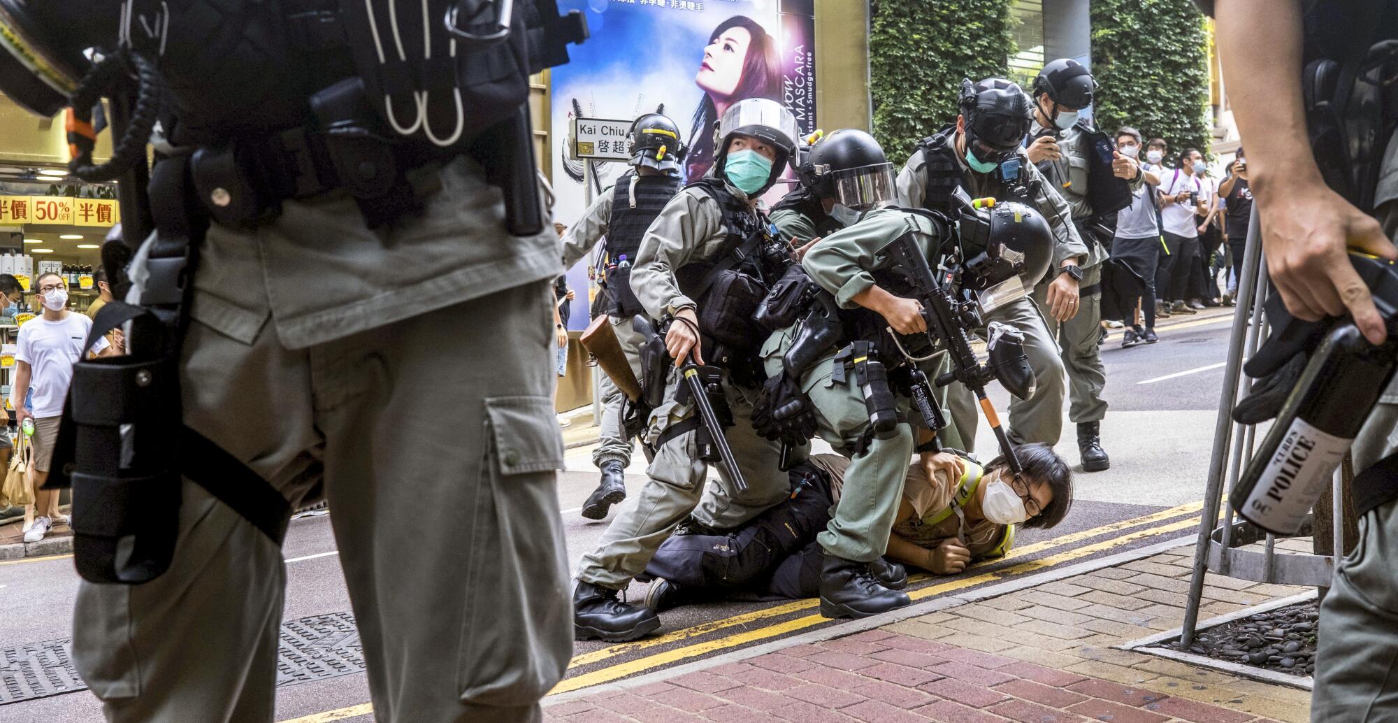 Riot police officers pin down a protester in Hong Kong.