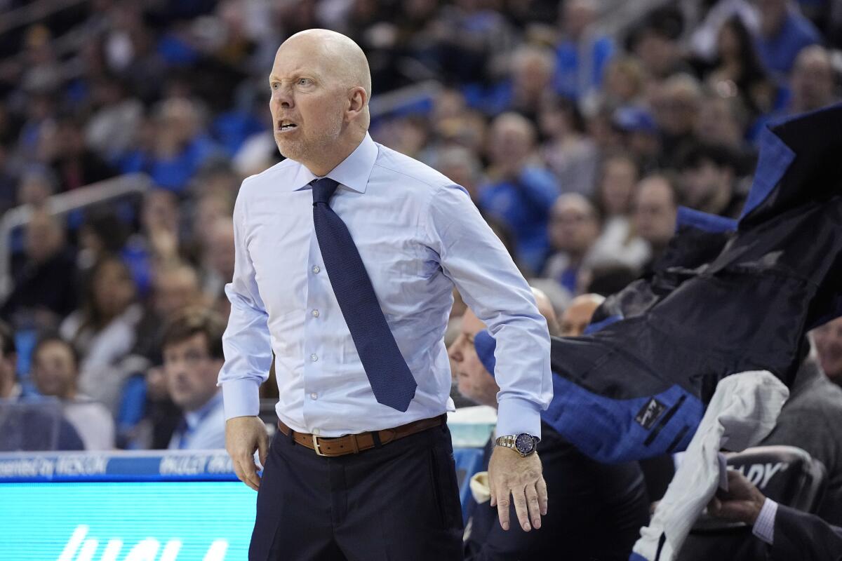 Mick Cronin steps forward with a furious expression, tossing his jacket behind him.