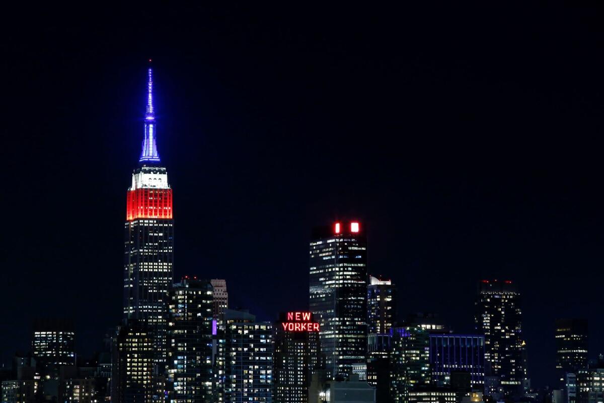 The Empire State Building in New York is lit in red, white and blue Tuesday as seen from Weehawken, N.J.