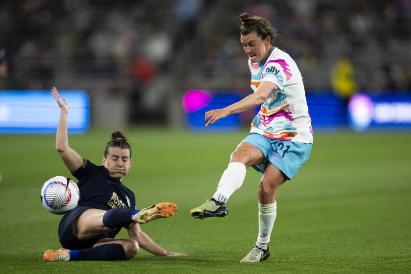 San Diego Wave midfielder Savannah McCaskill, right, shoots past Seattle Reign midfielder Angharad James during an NWSL soccer match, Friday, March 29, 2024, in San Diego. (AP Photo/Kyusung Gong)
