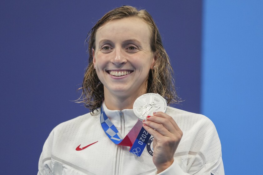 An Olympian holds up her silver medal.