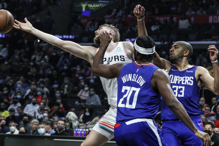Los Angeles, CA, Monday, December 20, 2021 - San Antonio Spurs center Jock Landale (34) stretches for a rebound as LA Clippers forward Justise Winslow (20) and LA Clippers forward Nicolas Batum (33) look on in the first half at Staples Center. (Robert Gauthier/Los Angeles Times)