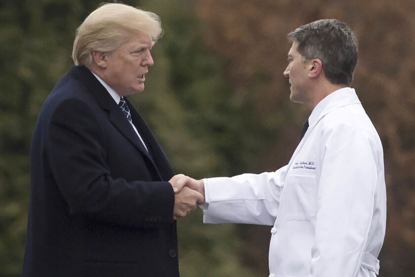(FILES) In this file photo taken on January 12, 2018 US President Donald Trump shakes hands with White House Physician Rear Admiral Dr. Ronny Jackson, following his annual physical at Walter Reed National Military Medical Center in Bethesda, Maryland. Presidential doctor Ronny Jackson withdrew his nomination to head the Department of Veterans Affairs on April 26, 2018 following allegations he improperly handed out drugs and was drunk at work."I am regretfully withdrawing my nomination to be Secretary for the Department of Veterans Affairs," Jackson said in a statement, insisting that "the allegations against me are completely false and fabricated." / AFP PHOTO / SAUL LOEBSAUL LOEB/AFP/Getty Images ** OUTS - ELSENT, FPG, CM - OUTS * NM, PH, VA if sourced by CT, LA or MoD **
