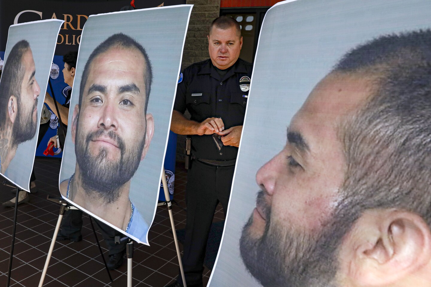 GARDEN GROVE, CA - AUGUST 08, 2019 — Cpl. Charles Starnes displays the photos of suspect Zachary Castaneda prior to a 1 pm press conference at Garden Grove police headquarters. (Irfan Khan/Los Angeles Times)