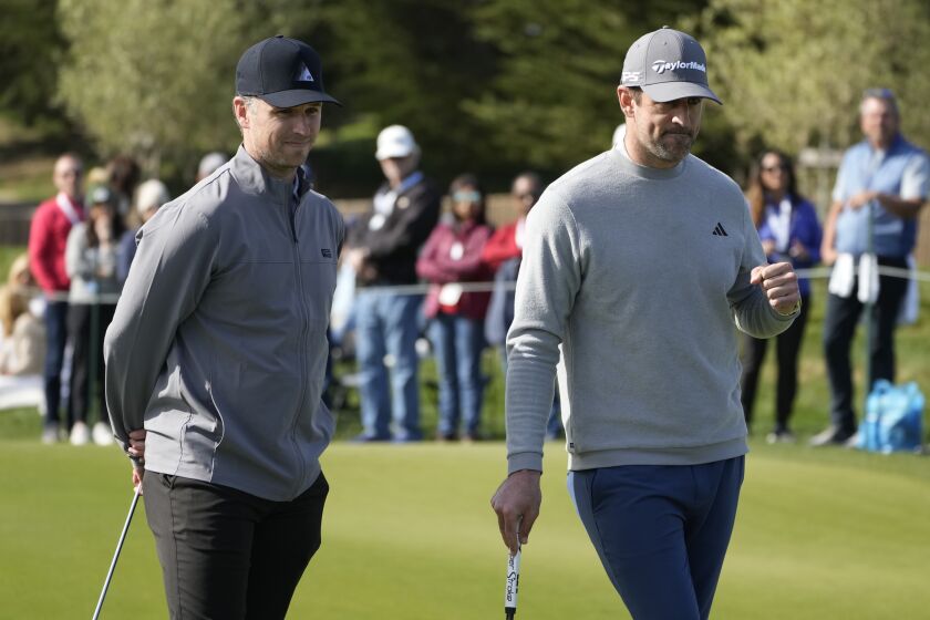 Buster Posey, left, and Aaron Rodgers watch during the putting challenge event of the AT&T Pebble Beach Pro-Am golf tournament in Pebble Beach, Calif., Wednesday, Feb. 1, 2023. (AP Photo/Eric Risberg)