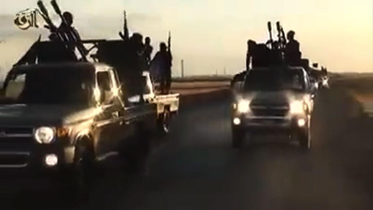 An image grab taken from a video released by Islamic State group's official Al-Raqqa site via YouTube on Sept. 23 purportedly shows recruits with the militant group riding in armed trucks in an unknown location.