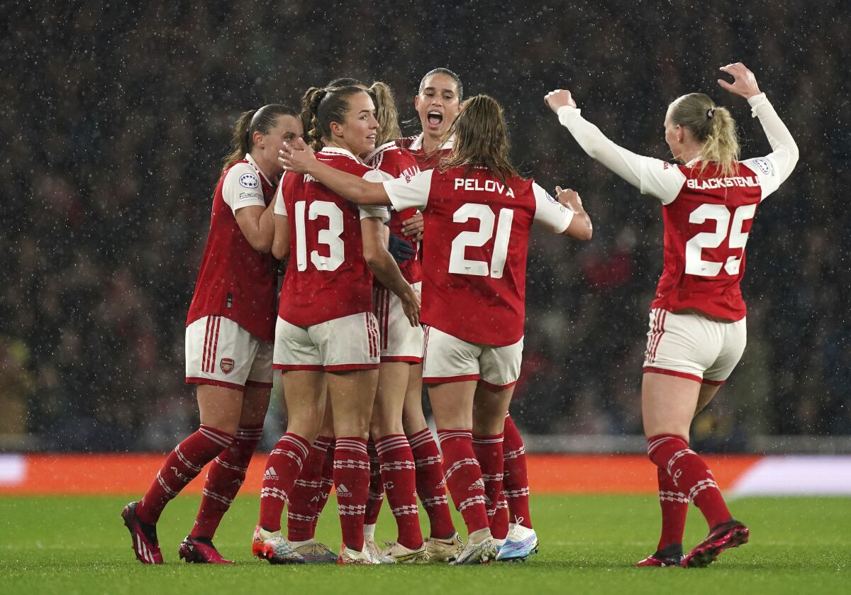 Arsenal's Frida Maanum, center obscured, is mobbed by team-mates after scoring their side's first goal during their Women's Champions League quarter final second leg soccer match against Bayern Munich at the Emirates Stadium, London, Wednesday, March 29, 2023. (Mike Egerton/PA via AP)