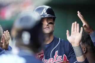 Atlanta Braves' Sam Hilliard high-fives teammates in the dugout after scoring on Travis d'Arnaud's double during the ninth inning of an opening day baseball game against the Washington Nationals at Nationals Park, Thursday, March 30, 2023, in Washington. (AP Photo/Alex Brandon)