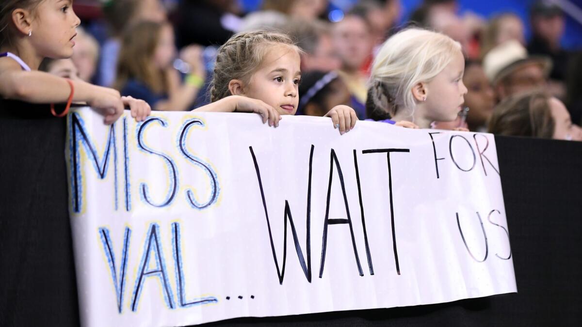 Children hold a sign for UCLA head coach Valorie Kondos Field.