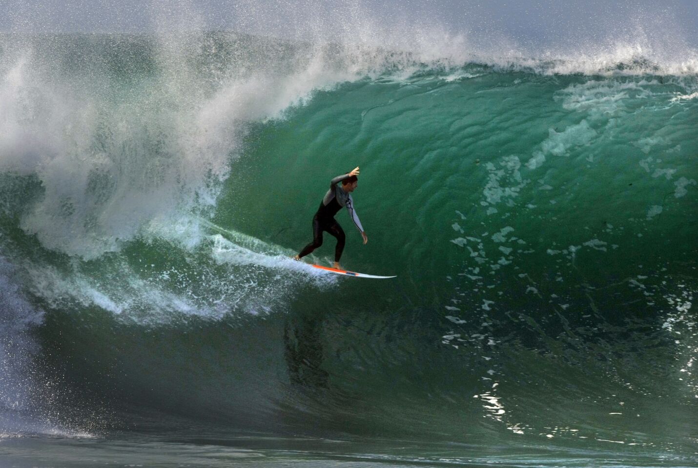 A surfer raises his arm to acknowledge a screaming crowd at the Wedge in Newport Beach. Thousands of spectators lined the beach Wednesday to watch waves as high as 25 feet tall generated by Hurricane Marie off the Pacific coast.