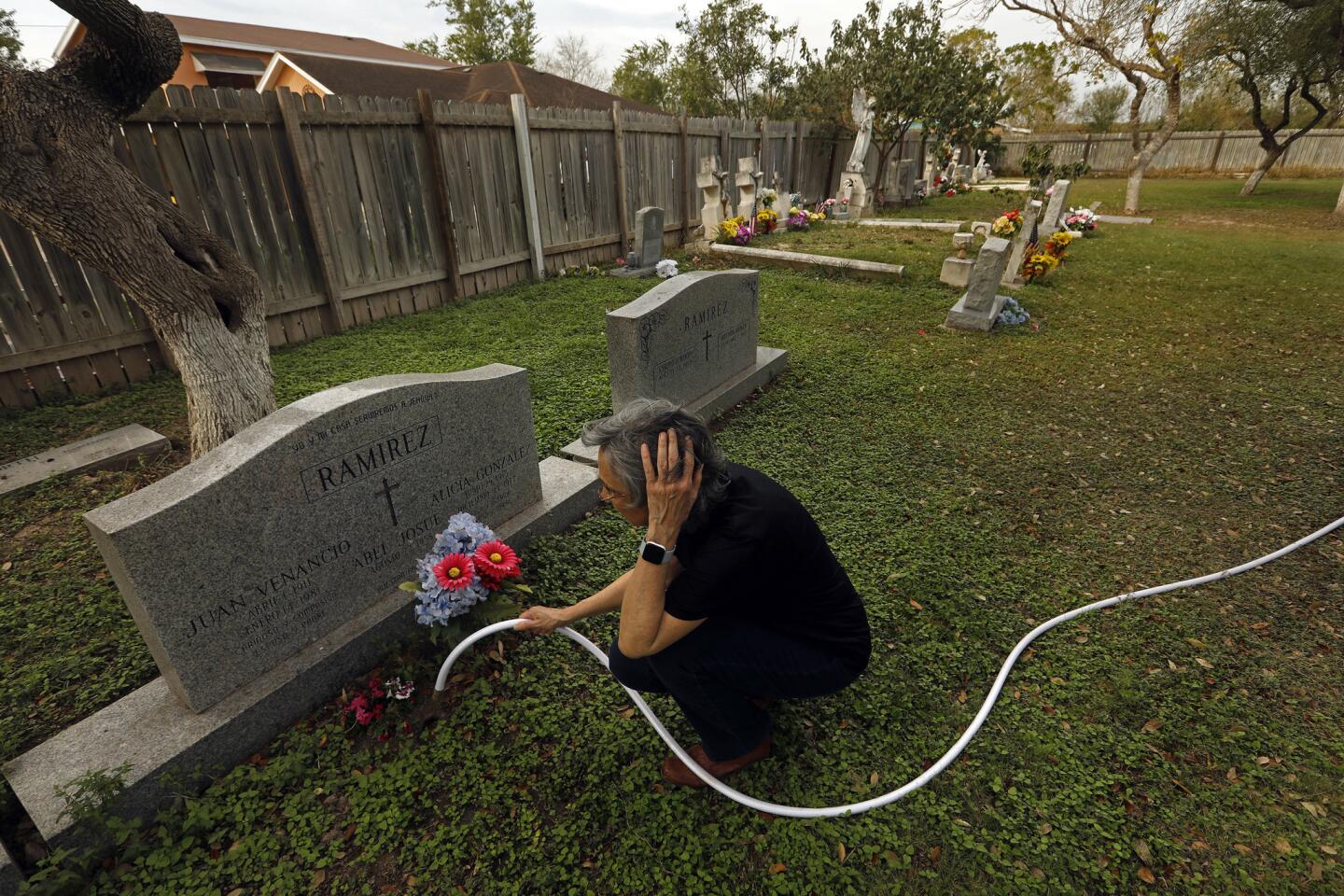 Sylvia Ramirez tends to the graves of her relatives in the Jackson Ranch Church Cemetery north of the Rio Grande. The Ramirez family is worried about plans for a border fence that could cut through or block access to historic cemeteries.