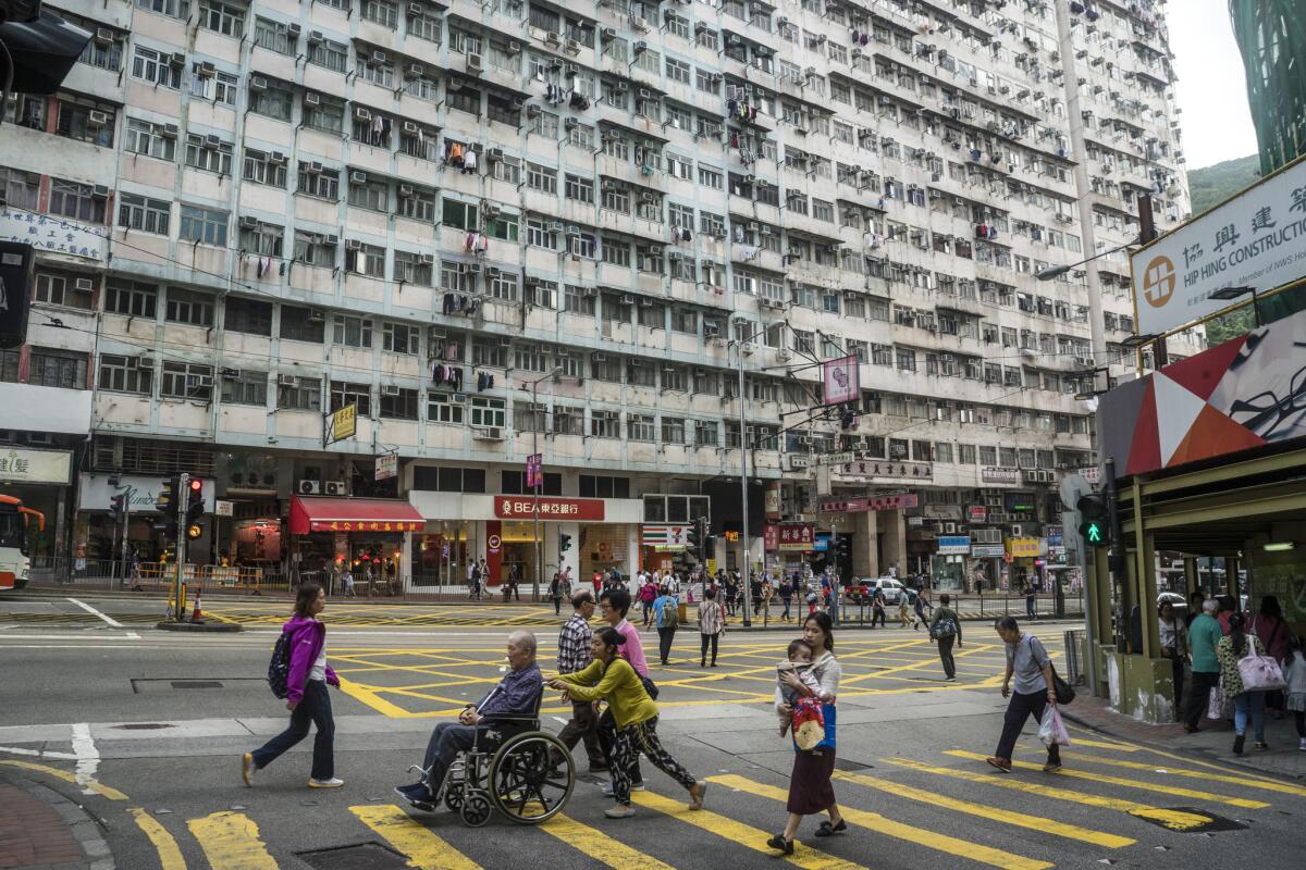Pedestrians walk past public housing built in the 1960s in Hong Kong.
