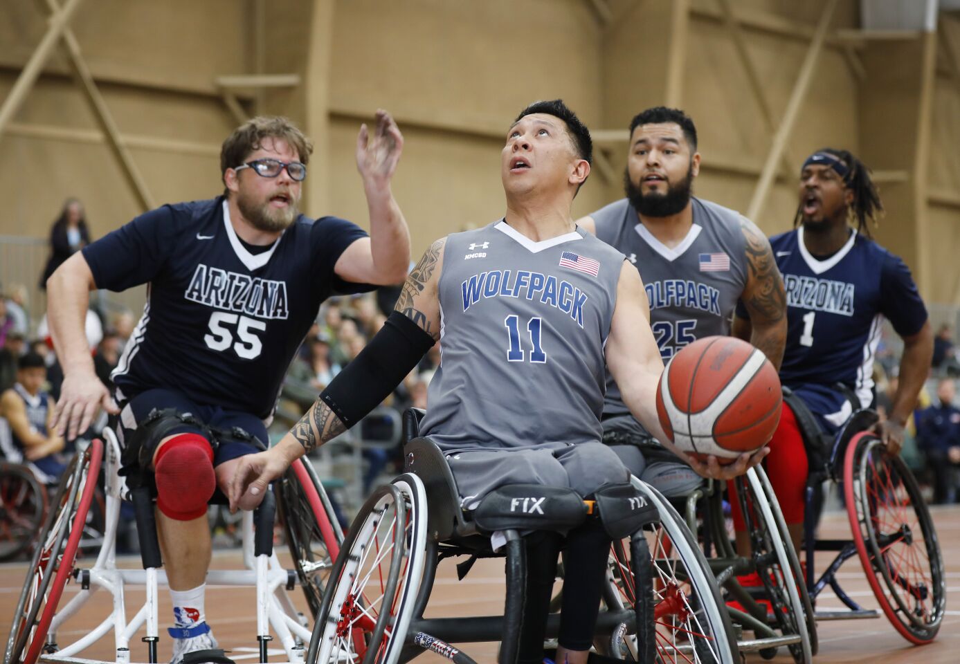 Jhoonar Barrera, center, of the Naval Medical Center San Diego Wolfpack goes for a shot as Karl Yates of the University of Arizona defends during the 4th Annual Brad Rich Invitational wheelchair basketball tournament at the Del Mar Fairgrounds on Feb. 9, 2020.