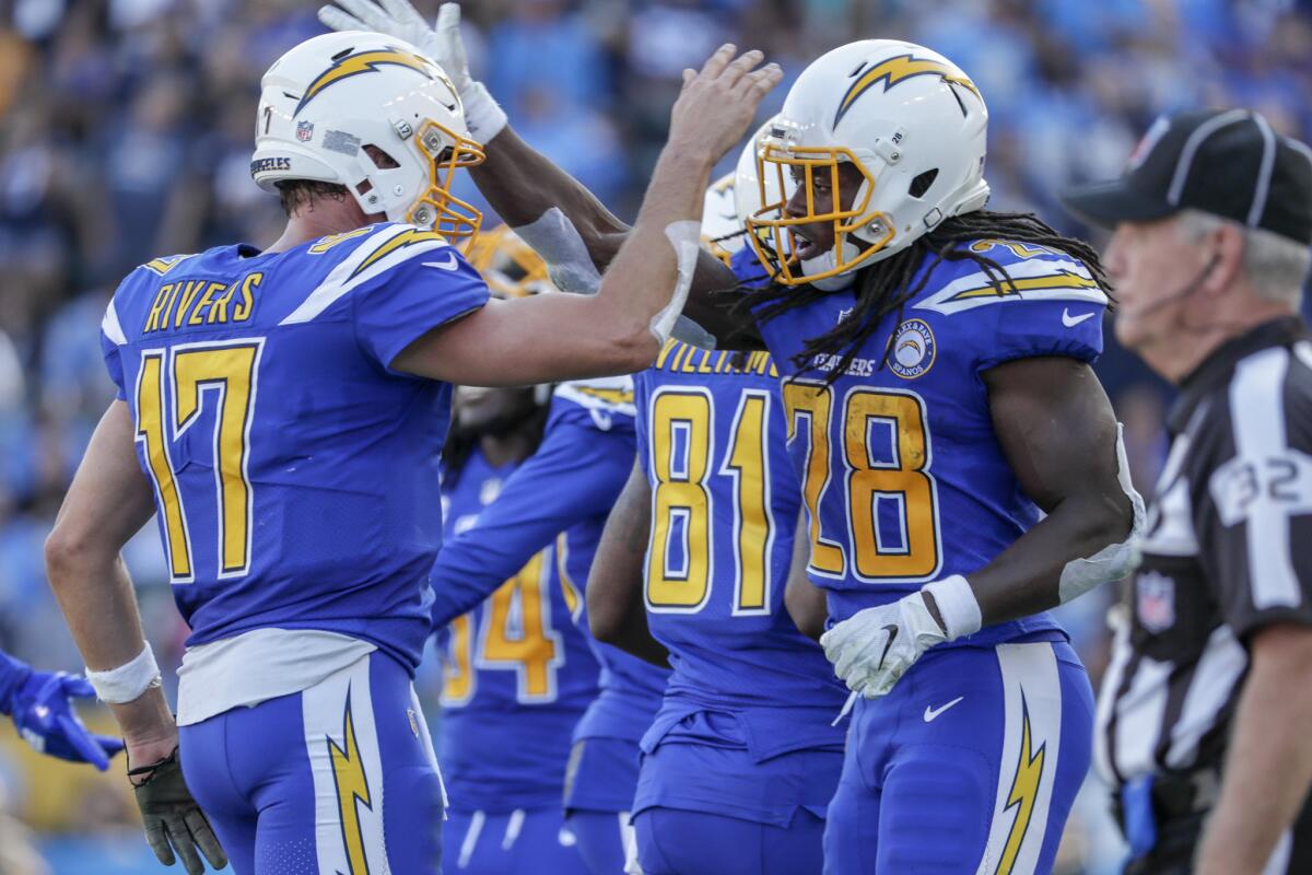 Melvin Gordon, right, and Philip Rivers celebrate on the sideline after Gordon scored on a 28-yard run in the first half at StubHub Center. Rivers set a passing record and Gordon had to leave because of an injury.