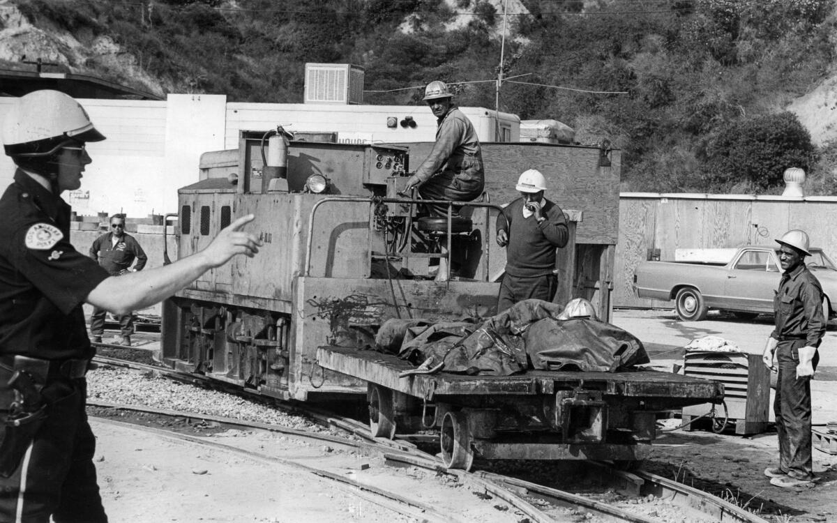 June 26, 1971: Remains of four of the workmen killed when a gas explosion ripped through Metropolitan Water District tunnel below Sylmar are brought out on mining train.