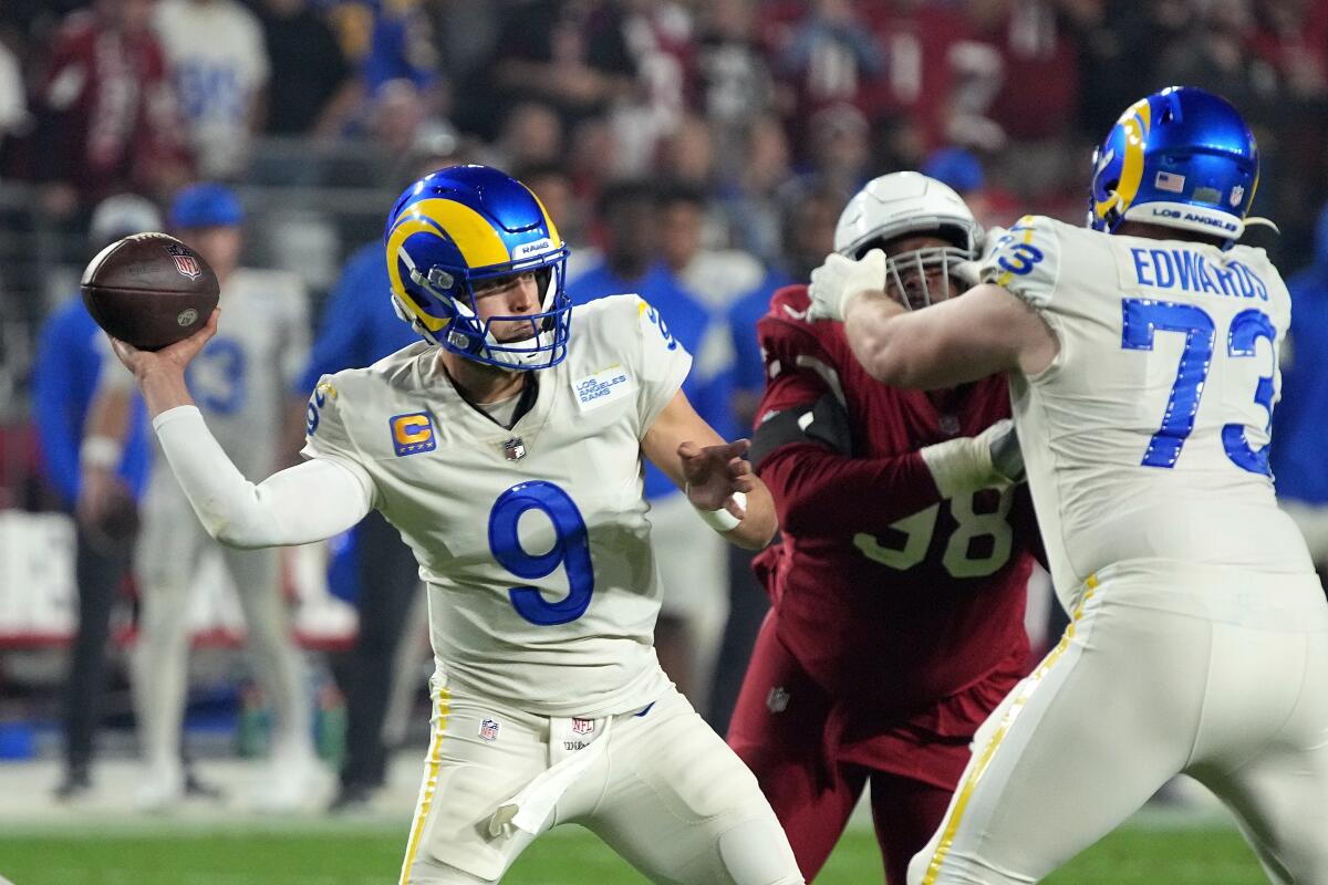 Rams quarterback Matthew Stafford (9) gets off a pass as Rams guard David Edwards (73) blocks Cardinals tackle Corey Peters.