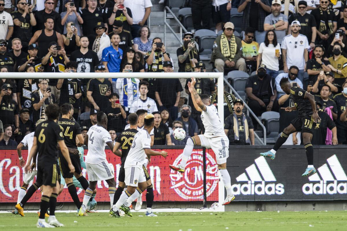 LAFC's José Cifuentes, airborne at right, scores a goal during the first half against the Galaxy on July 8, 2022.