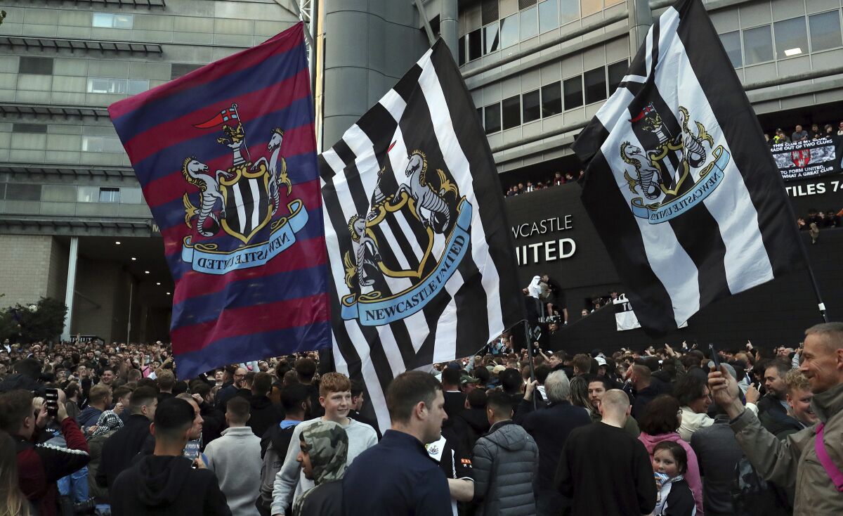 Newcastle United supporters celebrate outside St. James' Park in Newcastle Upon Tyne, England Thursday Oct. 7, 2021. English Premier League club Newcastle has been sold to Saudi Arabia’s sovereign wealth fund after a protracted takeover and legal fight involving concerns about piracy and rights abuses in the kingdom. (AP Photo/Scott Heppell)
