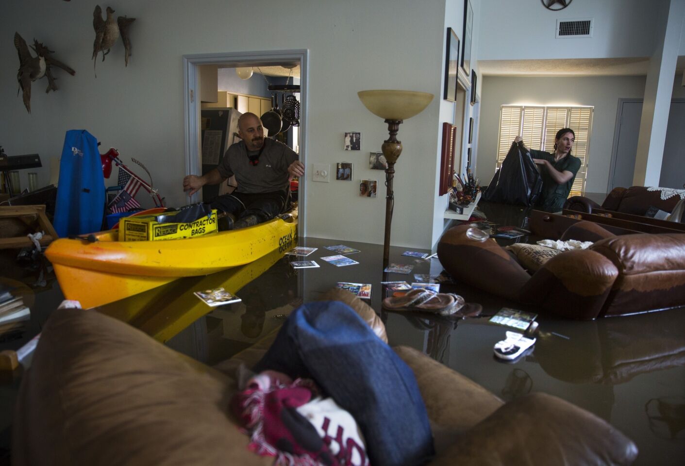 Larry Koser Jr., left and his son Matthew look for important papers and heirlooms inside Larry Koser Sr.'s house after it was flooded by heavy rains.