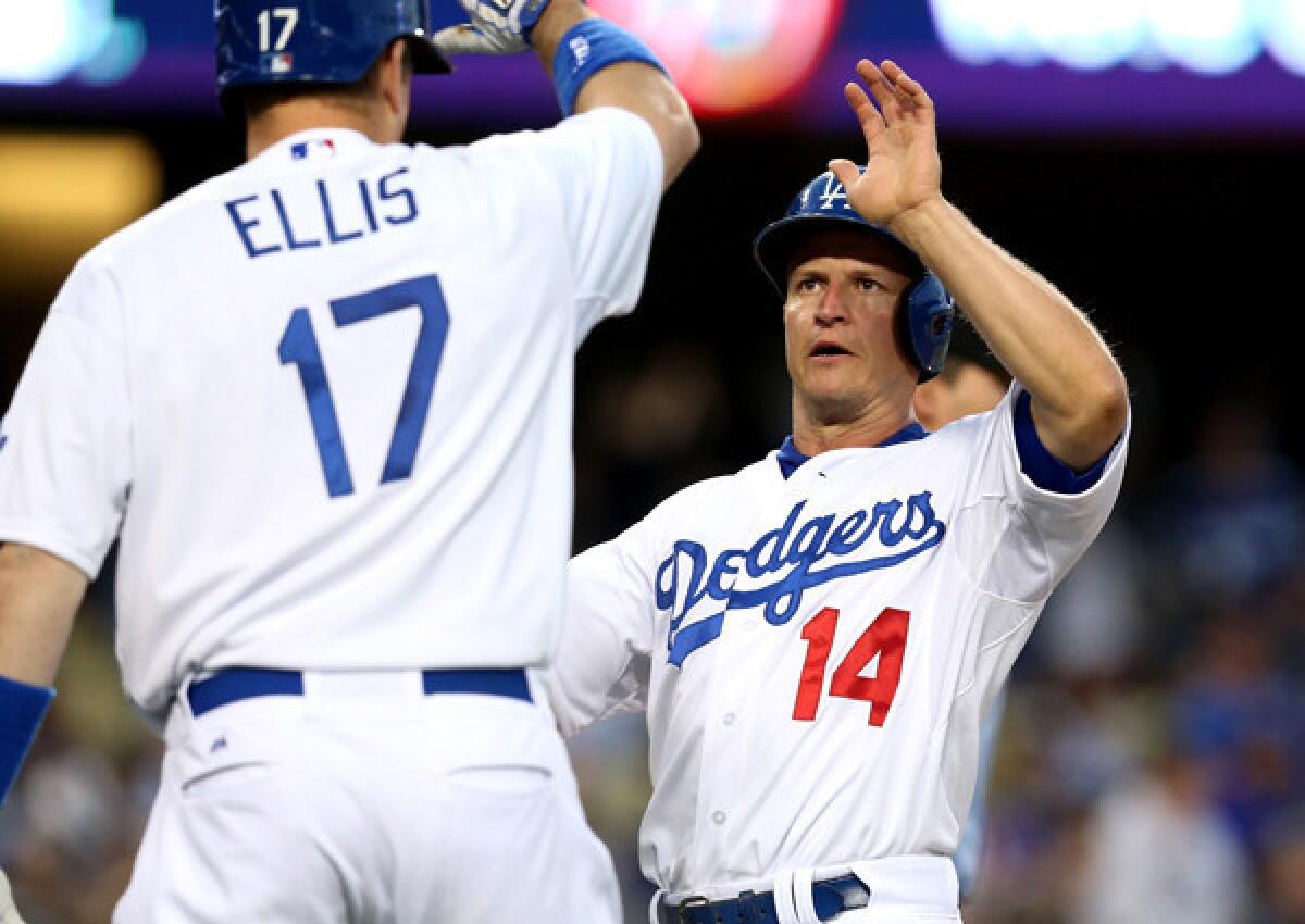 Dodgers second baseman Mark Ellis (14) is congratulated by catcher A.J. Ellis (17) after scoring in the first inning Friday night against the Brewers.