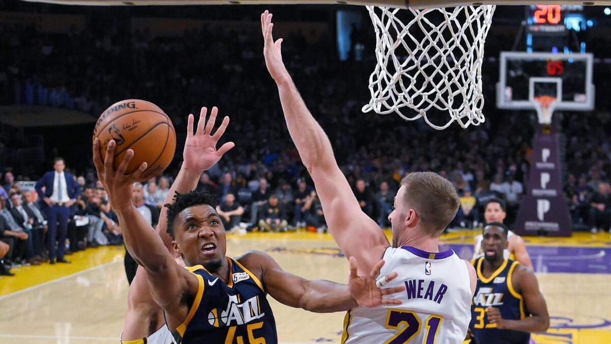 Utah Jazz guard Donovan Mitchell shoots as Los Angeles Lakers forward Travis Wear defends.