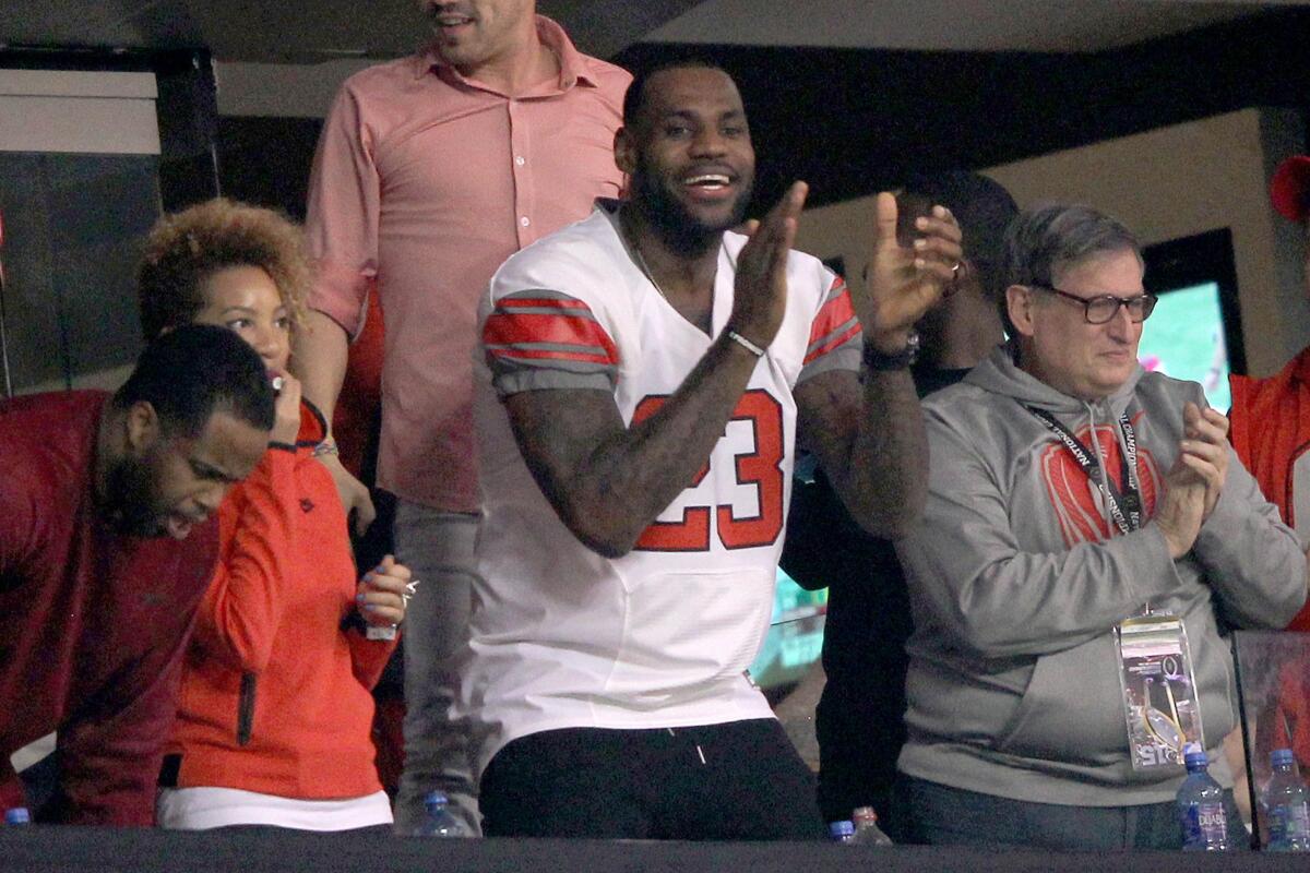 LeBron James wears a No. 23 Ohio State uniform while watching the Buckeyes play in the College Football Playoff title game.