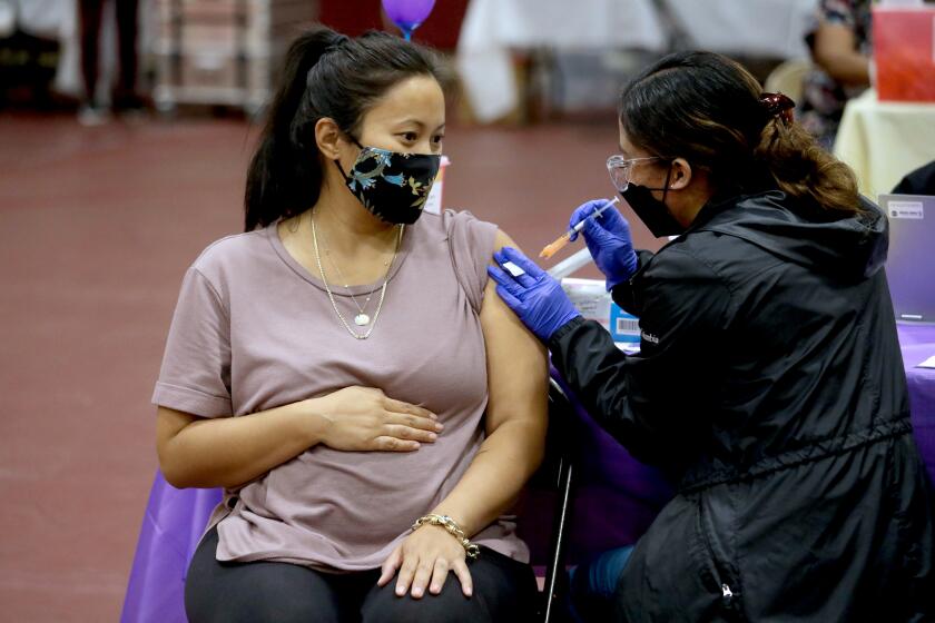 LOS ANGELES, CA - NOVEMBER 03: Nicole Fahey, of Altadena, six months pregnant, receives a Pfizer vaccination booster shot from RN Veronique (cq) Vida (cq) at Eugene A. Obregon Park on Wednesday, Nov. 3, 2021 in Los Angeles, CA. The County of Los Angeles, including Supervisor Hilda L. Solis, Dr. Barbara Ferrer, Director of Public Health, and Norma Edith Garcia-Gonzalez, Director of Parks and Recreation, will host a media event kicking off COVID-19 vaccinations for children ages 5-11 in Los Angeles County. The COVID-19 vaccine manufactured by Pfizer and BioNTech is proposed to be given in two 10-microgram (mcg) doses administered 21 days apart. (Gary Coronado / Los Angeles Times)