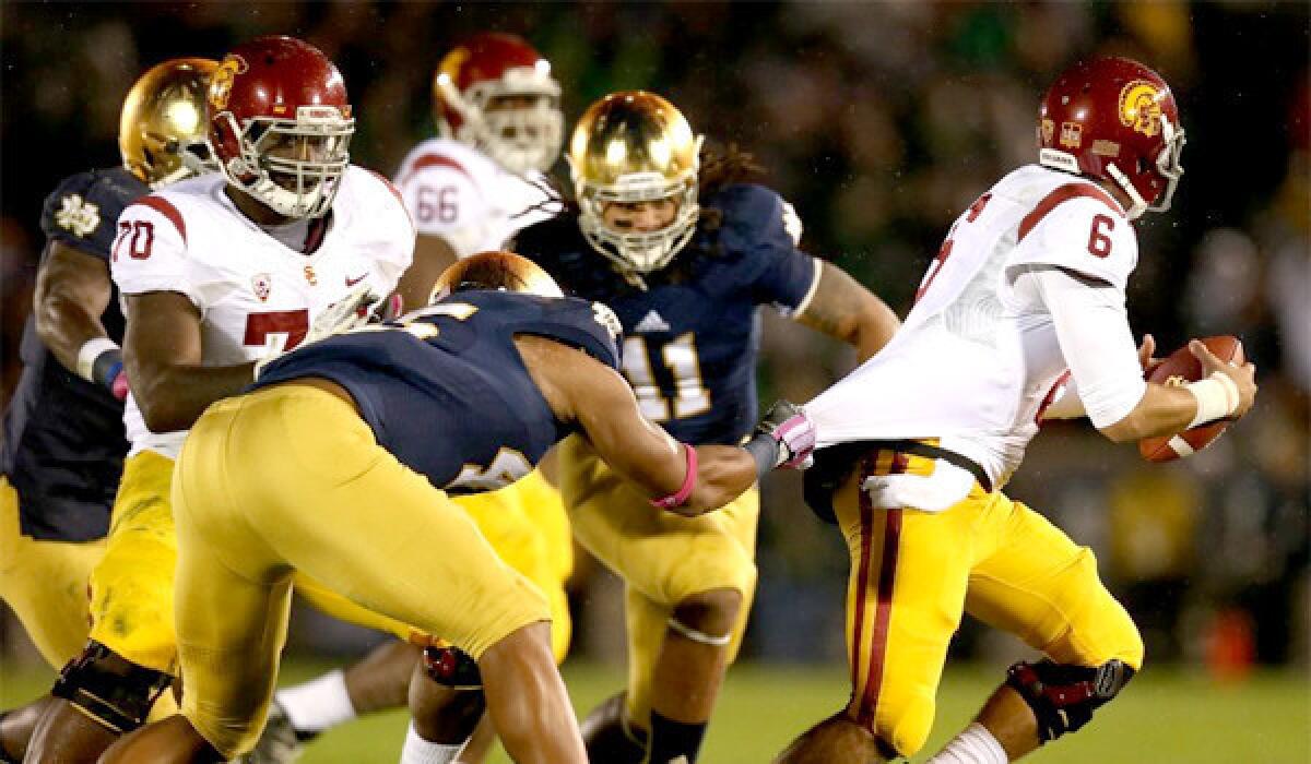 USC quarterback Cody Kessler tries to escape from Notre Dame linebacker Romeo Okwara during the Trojans' 14-10 loss to the Fighting Irish on Saturday.